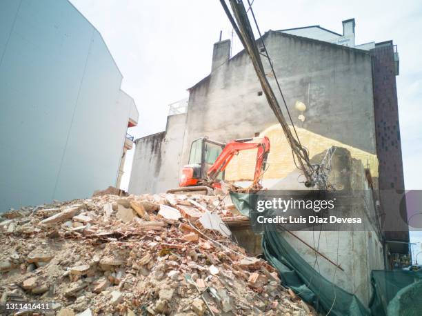 demolition vehicle amid the dust and rubble. - aas fressen stock-fotos und bilder