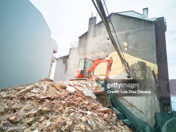 demolition vehicle amid the dust and rubble. - building collapsing stock pictures, royalty-free photos & images