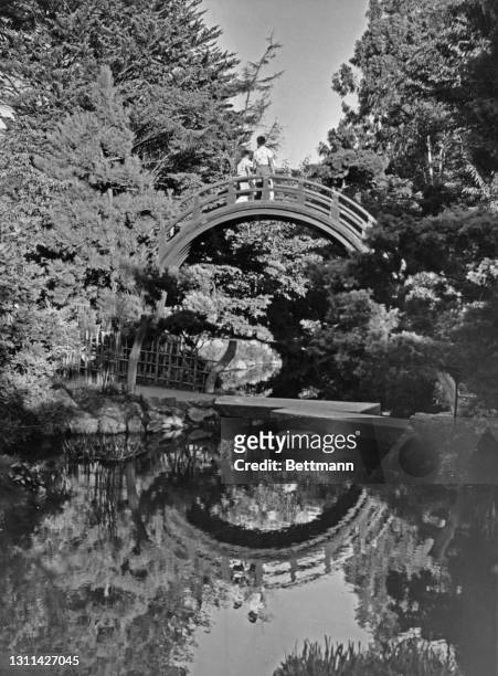 Visitors on the Moon Bridge, a pedestrian footbridge at the Japanese Tea Garden, in Golden Gate Park, San Francisco, California, circa 1955. The...