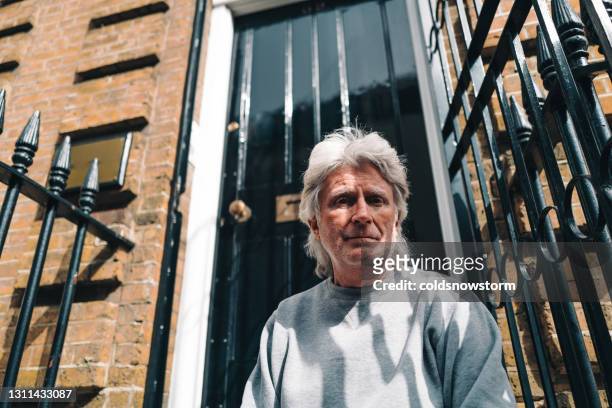 homeless senior man sitting on steps on city street - homeless man stock pictures, royalty-free photos & images