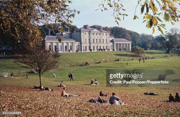 Visitors lie on the grass in front of Kenwood House, a former stately home on the northern edge of Hampstead Heath in Hampstead, London circa 1970....