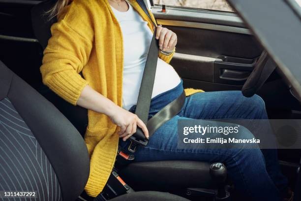 pregnant woman fastening safety belt in car - seat belt stock pictures, royalty-free photos & images