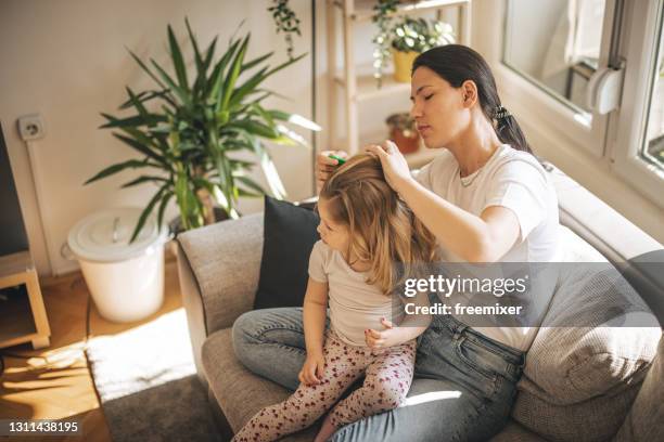 mother doing head lice cleaning on daughter - louse stock pictures, royalty-free photos & images