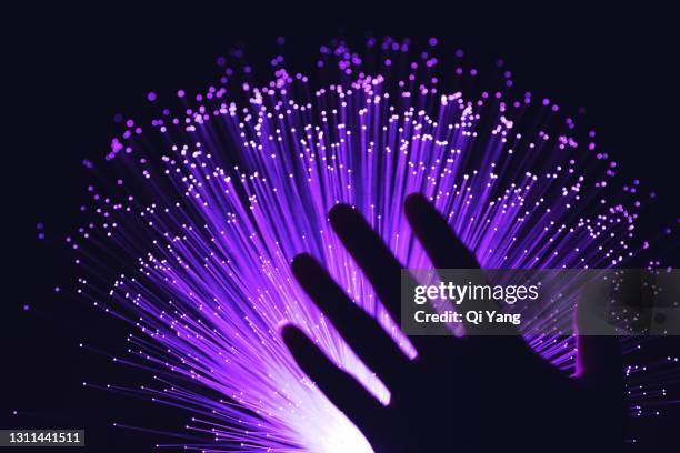 hand touching green optical fiber - igniting ストックフォトと画像