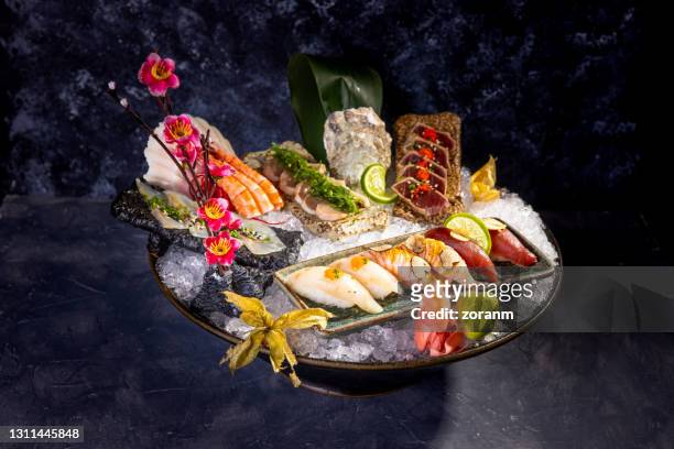 sashimi und tataki in servierschale voller eis mit dekoration - sashimi stock-fotos und bilder