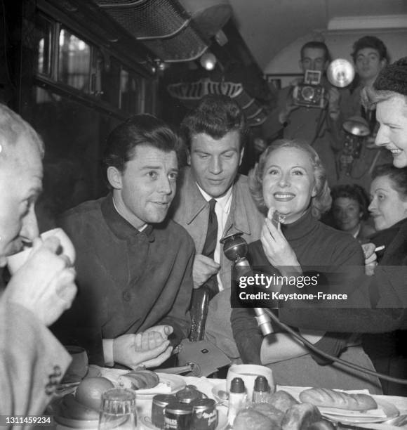 Gérard Philipe, Raymond Borderie et Michèle Morgan prenant le petit-déjeuner dans un train, en octobre 1948.