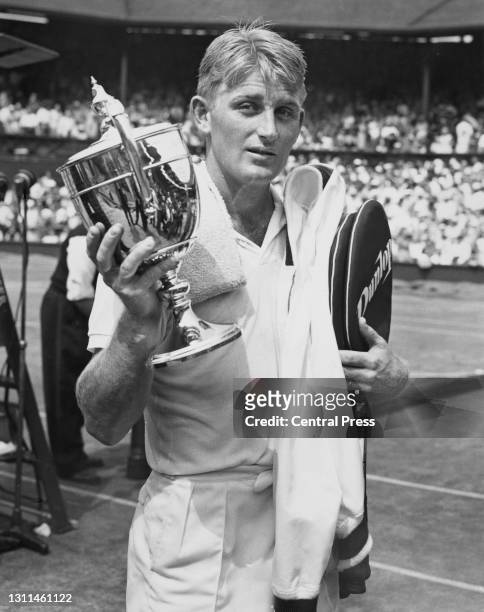 Lew Hoad of Australia poses for photographs holding the Gentlemen's Singles Trophy after defeating compatriot Ashley Cooper in their Men's Singles...