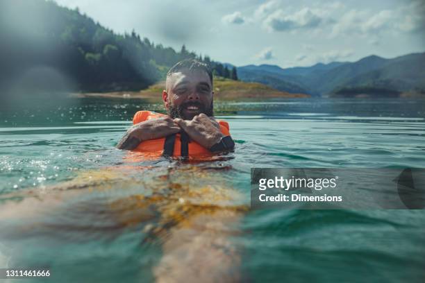 male with life jacket in lake - life jacket stock pictures, royalty-free photos & images
