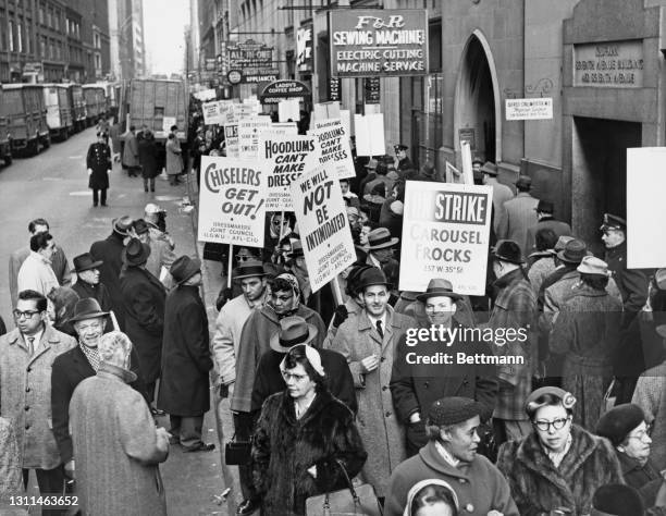 Members of the International Ladies Garment Workers Union , carrying placards reading 'Chiselers Get Out!', 'Hoodlums Can't Make Dresses', 'We Will...