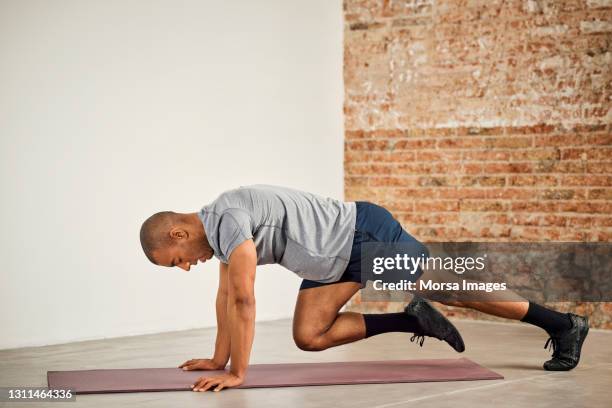 sportsman practicing mountain climbing exercise - mountain-climbing stock pictures, royalty-free photos & images