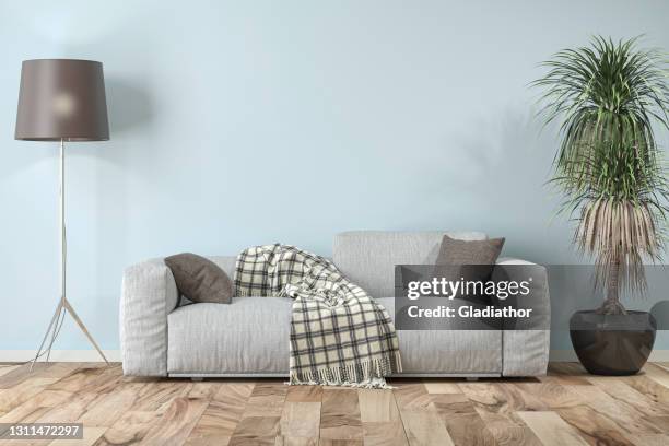 elegantes wohnzimmer mit sofa auf hellblau-weißem gipswandhintergrund - wohnzimmer frontal stock-fotos und bilder