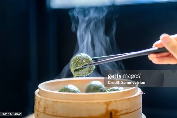 close-up of chinese traditional green dumplings on wooden table - dim sum stock-fotos und bilder
