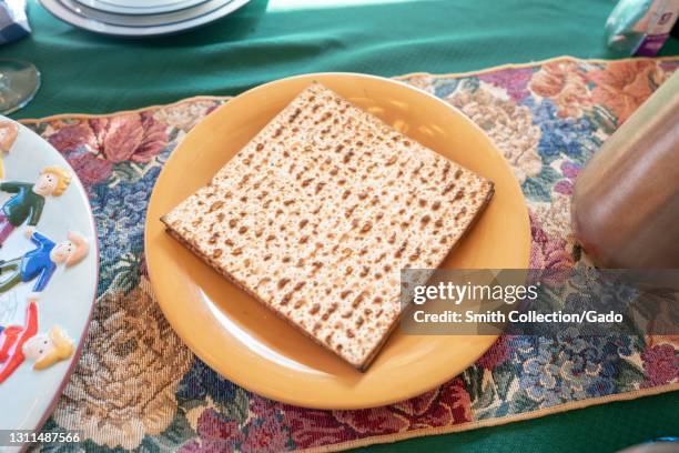 Table in suburban home set for the ritual Seder meal for the holiday Pesach in Judaism, Lafayette, California, with plate of matzah visible, March...