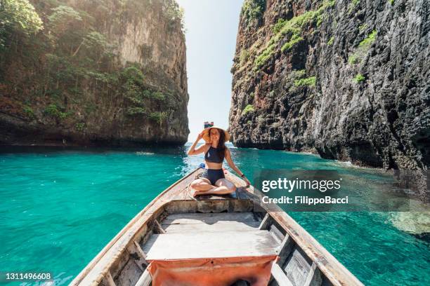 young woman on a longtail boat in thailand, phi phi island - longtail boat stock pictures, royalty-free photos & images
