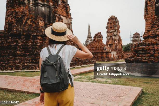 young woman exploring a temple in ayutthaya, thailand - ayuthaya imagens e fotografias de stock