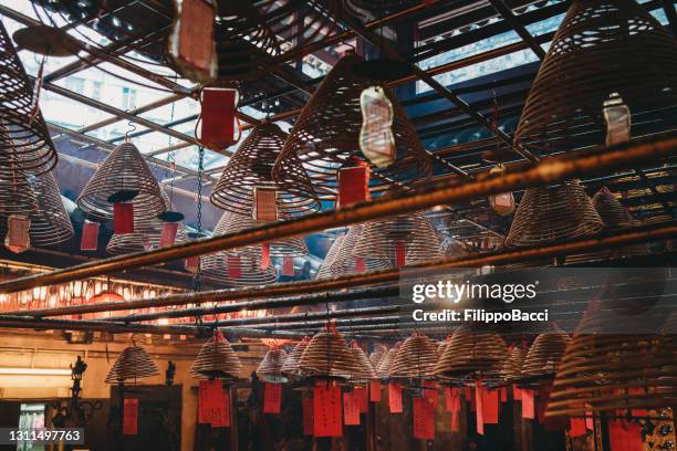 templo man mo em hong kong com raios solares e incenso - templo de man mo - fotografias e filmes do acervo