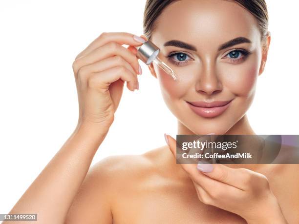 beautiful girl getting skin anti aging treatment - applying oil stock pictures, royalty-free photos & images