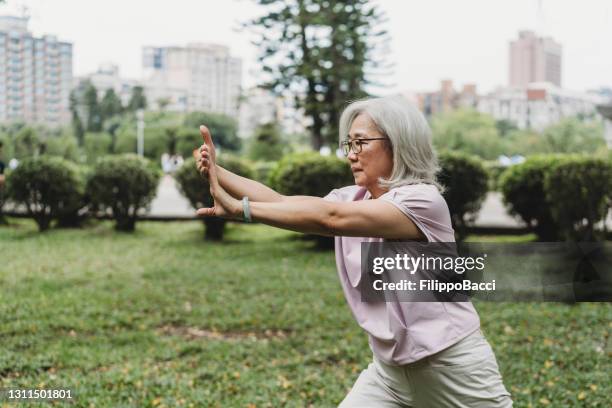 seniorin übt yoga im öffentlichen park - chinese taipei stock-fotos und bilder