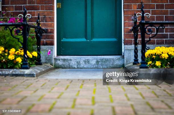 front door with decorative plants - doorstep stock pictures, royalty-free photos & images