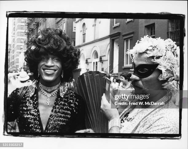 View of American gay liberation activist Marsha P Johnson during the Pride March , New York, June 27, 1982. The masked marcher at right is...