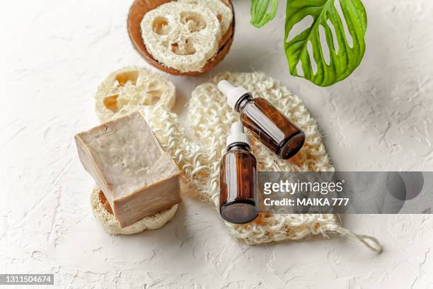 toiletries, aleppo soap and vitamin c serum in cosmetic bottles with dropper on white background - loofah stock pictures, royalty-free photos & images