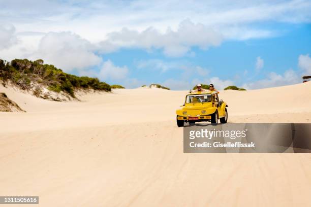 paar reitet im sommer im rücken eines strandbuggys - couple dunes stock-fotos und bilder