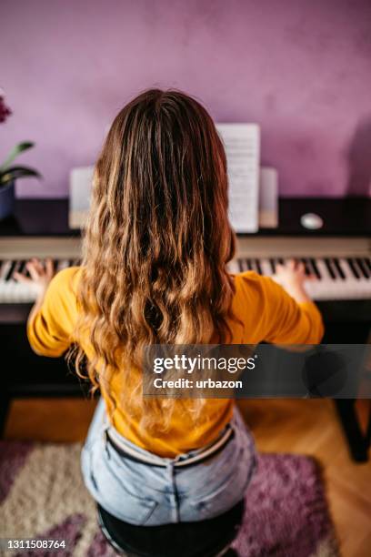 joven tocando el piano en casa - keyboard player fotografías e imágenes de stock