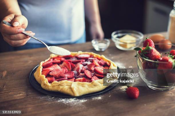 young woman preparing strawberry galette or open strawberry pie - strawberry tart stock pictures, royalty-free photos & images