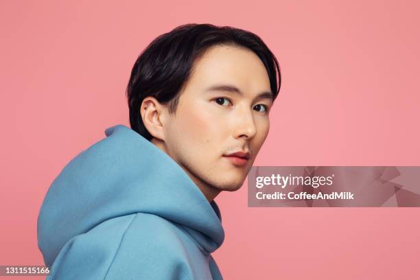 emotional asian man wearing hoodie - young male model stock pictures, royalty-free photos & images