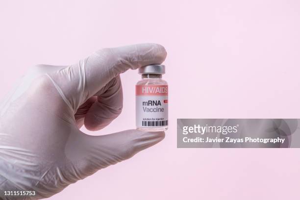 mrna vaccine vial for hiv/aids on pink background - aids stockfoto's en -beelden