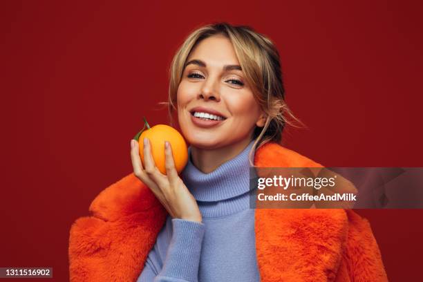 bella donna sorridente - orange coat foto e immagini stock