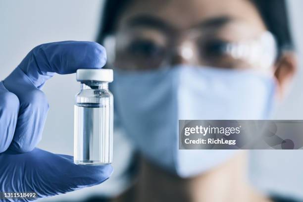 asiatisk kvinna som håller vaccinflaska - medicinflaska bildbanksfoton och bilder