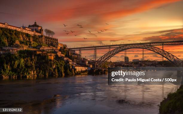 view of bridge over river against cloudy sky during sunset,porto,portugal - oporto fotografías e imágenes de stock