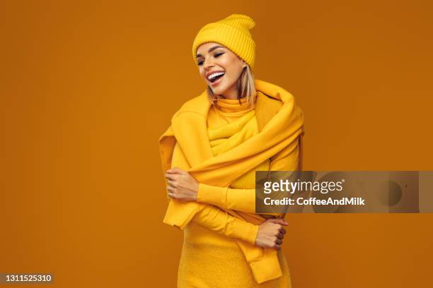 portret van een jonge vrouw die gele sweater en hoed draagt - scarf isolated stockfoto's en -beelden
