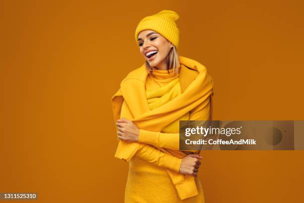 portrait of a young woman wearing yellow sweater and hat - winter fashion stock pictures, royalty-free photos & images