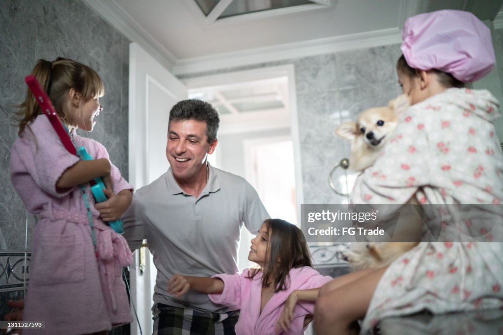 Father playing with daughters in the bathroom at home