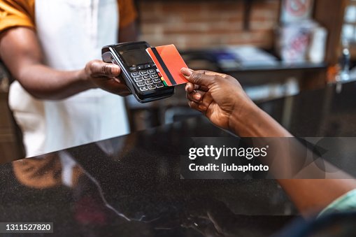 Foto recortada de una mujer irreconocible que pagaba su compra con tarjeta Foto recortada de una mujer irreconocible que pagaba su compra con tarjeta