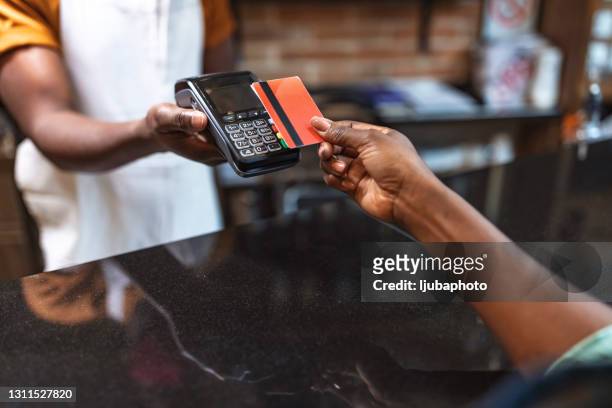 一個無法辨認的女人用卡支付購買費用的裁剪鏡頭 - 付錢 個照片及圖片檔