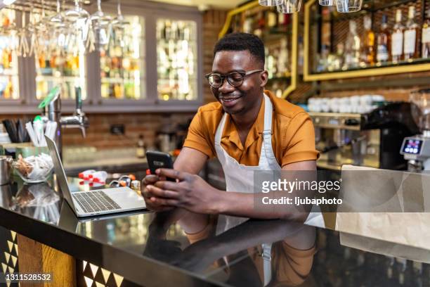 een drukke ondernemer moet verbonden blijven - african american restaurant texting stockfoto's en -beelden
