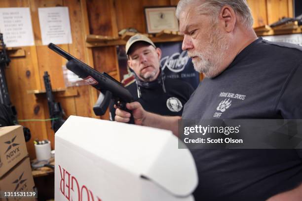 Fred Lutger , the owner of Freddie Bear Sports, and Matt Collins look over a shipment of guns that arrived at the sporting goods store on April 08,...