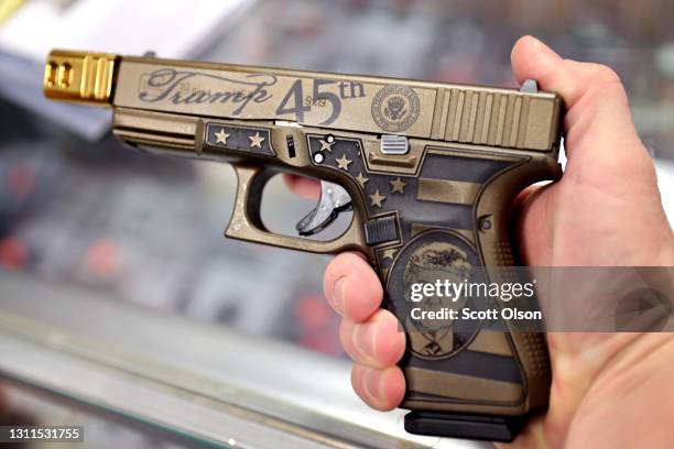 Worker shows off Glock 19 Donald Trump commemorative 9mm pistol being offered for sale at Freddie Bear Sports on April 08, 2021 in Tinley Park,...