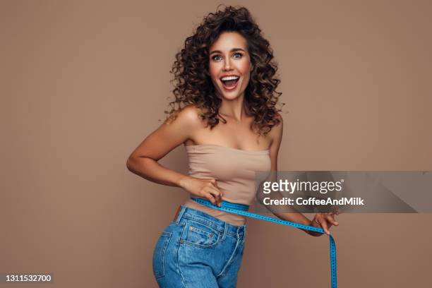 young woman losing weight - slim stock pictures, royalty-free photos & images