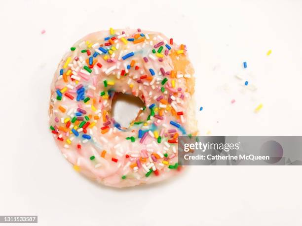 fresh glazed doughnut with strawberry icing & rainbow sprinkles - yoyo dieting stock pictures, royalty-free photos & images