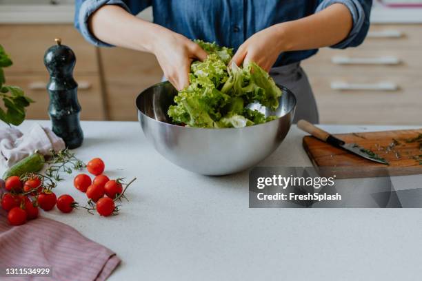 anonymous woman mixing the salad in the kitchen (copy space) - salad tossing stock pictures, royalty-free photos & images