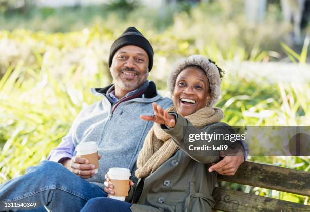 african-american relaxing on park bench drinking coffee - season 61 stock pictures, royalty-free photos & images