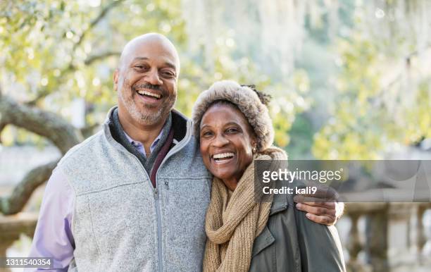 casal afro-americano maduro no parque - casaco - fotografias e filmes do acervo