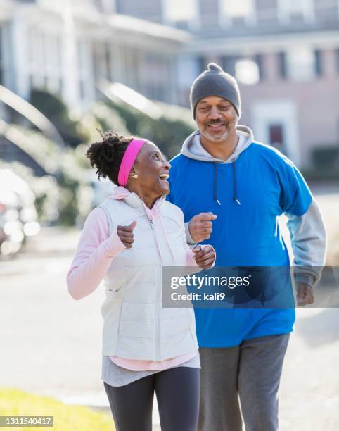 mature african-american couple out for a walk or jog - 55 to 60 years old african american male stock pictures, royalty-free photos & images