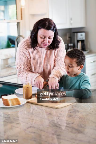 mother, son making peanut butter sandwich in kitchen - making sandwich stock pictures, royalty-free photos & images