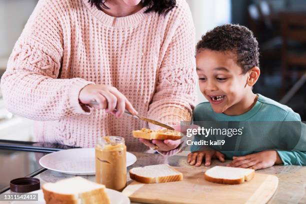 mother, son making peanut butter sandwich in kitchen - making a sandwich stock pictures, royalty-free photos & images