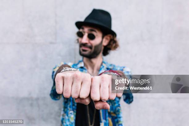 caucasian man showing knuckles while standing in front of wall - knuckle ストックフォトと画像